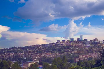 Panoramablick auf eine Stadt mit moderner Skyline und bewölktem Himmel.