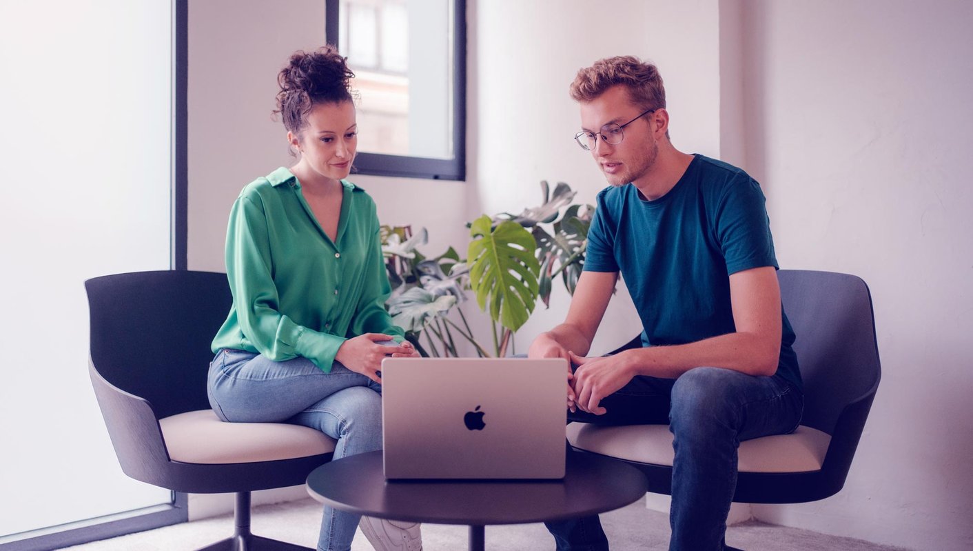 Zwei Personen besprechen Projekt am Laptop.
